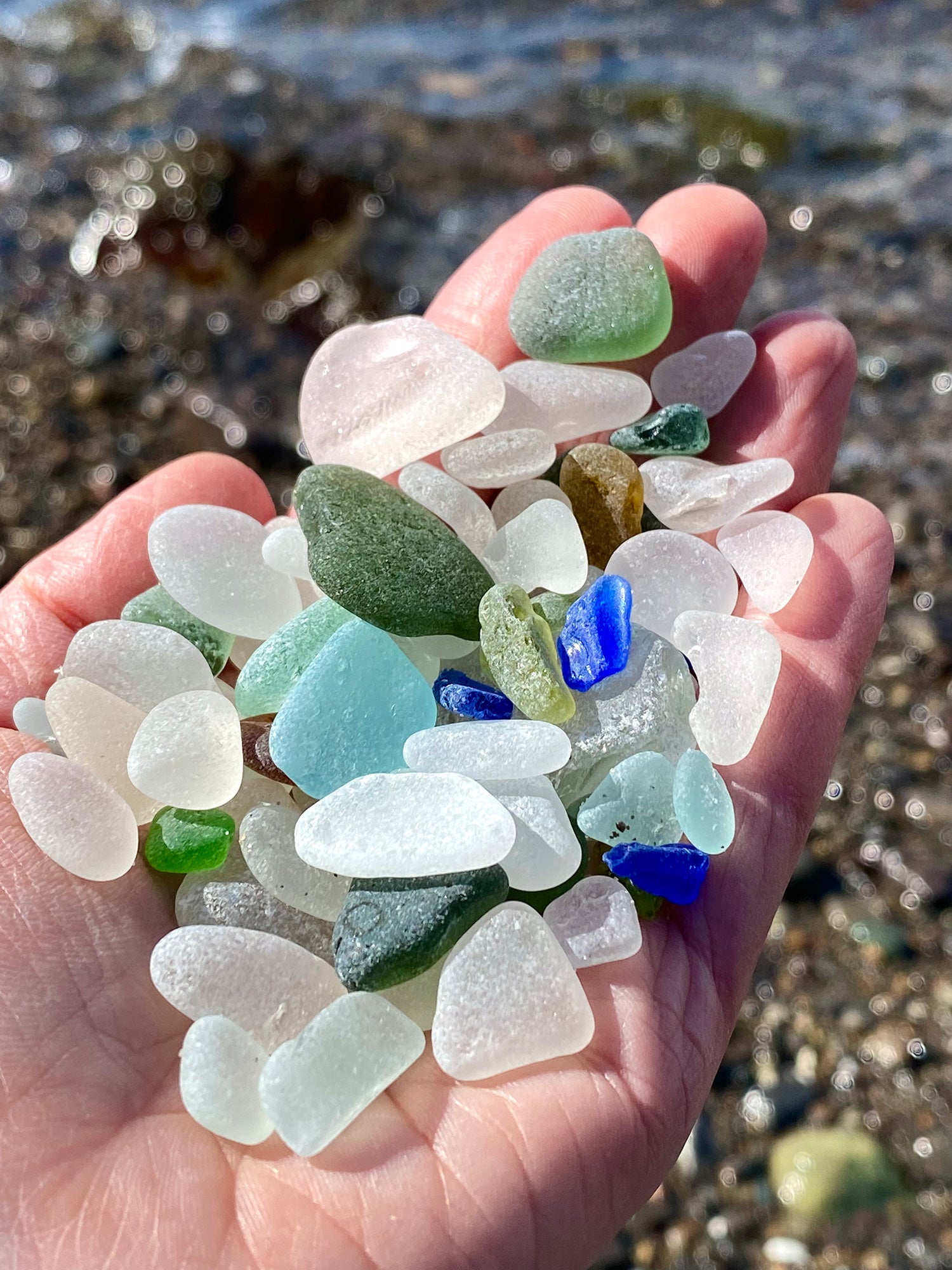 sea glass in hand at the beach